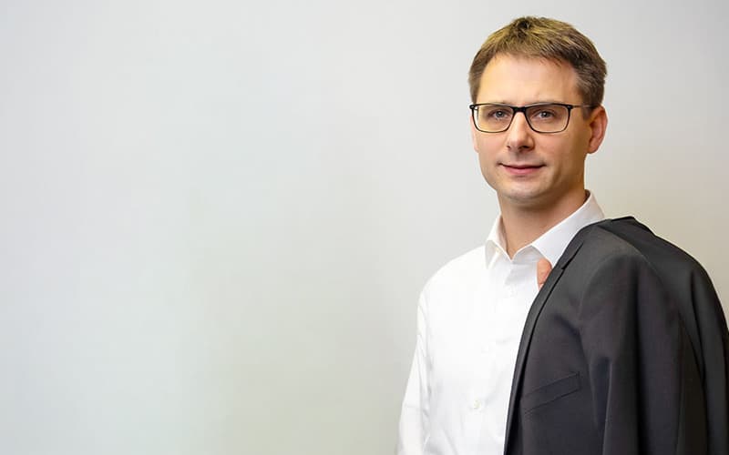 Steuerberater Marcel Kröll mit Sakko über der Schulter